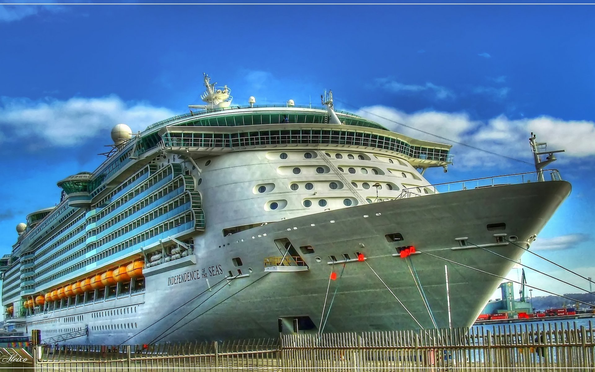 HD desktop wallpaper featuring the cruise ship Independence of the Seas docked under a bright blue sky.