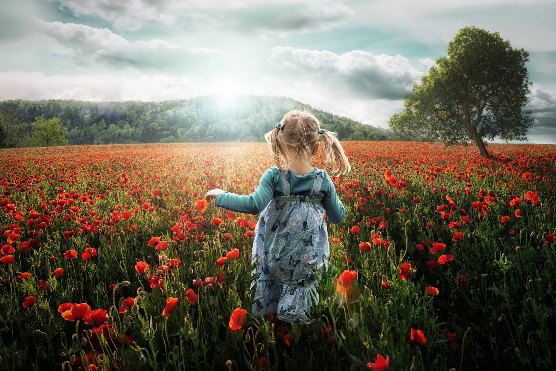 A little girl runs through a vibrant poppy field, surrounded by lush greenery and a bright sky, capturing a joyful moment in nature. A stunning HD wallpaper for any desktop background.