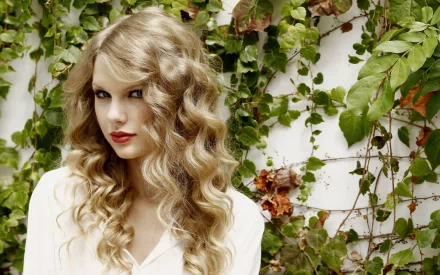 HD desktop wallpaper featuring Taylor Swift with beautiful curly hair, surrounded by lush green vines, embodying a vibrant musical spirit.