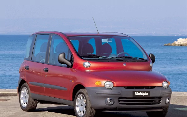 HD PC desktop wallpaper featuring a red Fiat Multipla vehicle parked by the waterfront with clear blue skies and calm sea in the background.