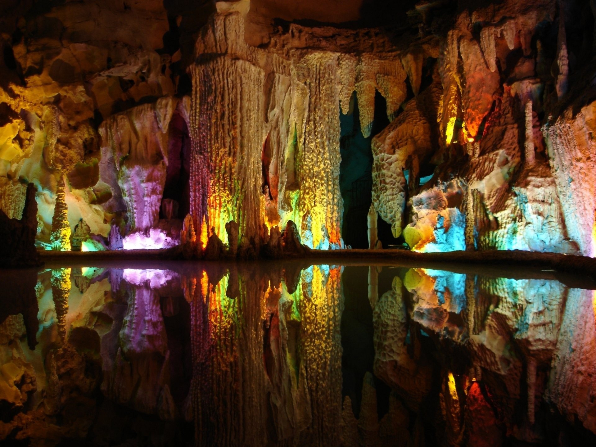 HD PC wallpaper of Ali-Sadr Cave showcasing colorful stalactites and stalagmites reflected in tranquil water, highlighting the natural beauty of this famous cave.