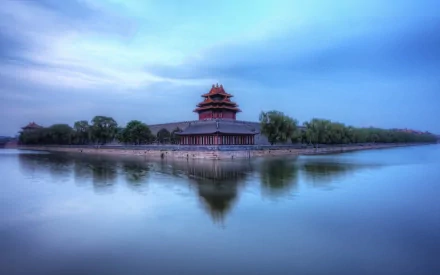 A serene view of a pagoda at the Forbidden City, reflected in calm water under a soft blue sky. This captivating image serves as a stunning HD desktop wallpaper.