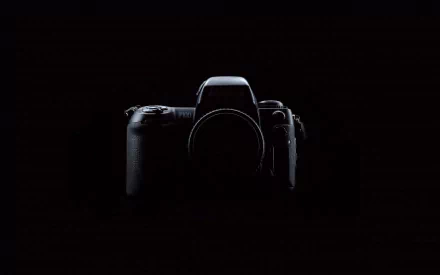 A sleek camera stands out against a dark background, creating an artistic focal point for a high-definition PC desktop wallpaper.