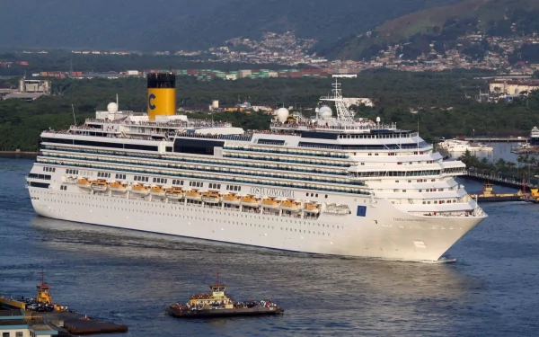 HD desktop wallpaper featuring the cruise ship Costa Concordia sailing near a coastal city with mountains in the background.
