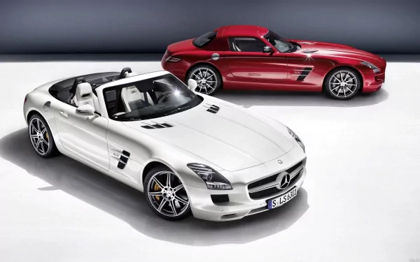 A striking white Mercedes-Benz SLS AMG convertible is showcased in the foreground, with a sleek red SLS AMG in the background, set against a clean, modern backdrop.