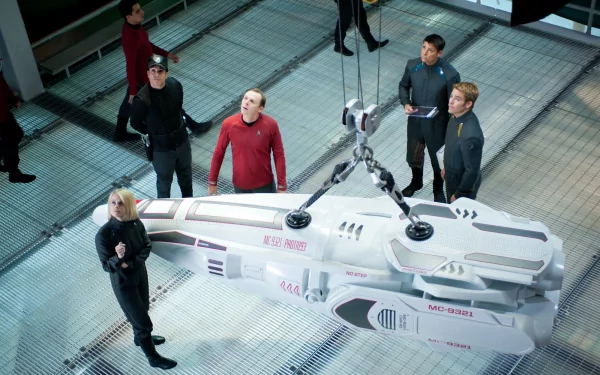 HD PC desktop wallpaper from the movie Star Trek Into Darkness showing the crew gathered around a futuristic shuttlecraft inside a high-tech facility.
