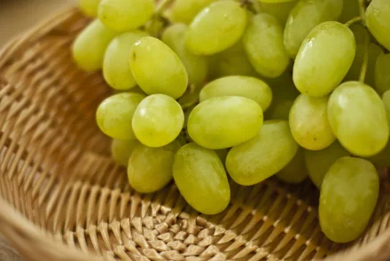 Close-up of fresh green grapes in a woven basket, captured in sharp detail as a vibrant 4K Ultra HD PC desktop wallpaper and background.