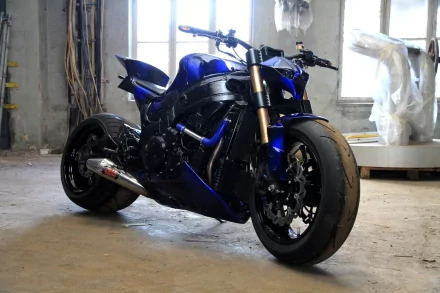 HD PC desktop wallpaper featuring a sleek, blue motorcycle parked indoors with natural light from windows illuminating its detailed design.