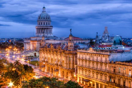 HD PC desktop wallpaper featuring a beautifully illuminated man-made townscape at dusk with historic architecture and a prominent domed building under a blue sky.
