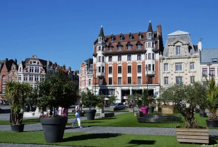 HD desktop wallpaper showing a charming man-made town square with historic buildings, greenery, and potted trees under a clear blue sky.