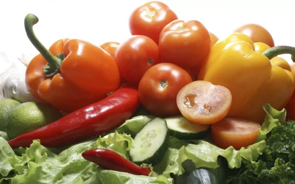 HD PC desktop wallpaper featuring fresh tomatoes, bell peppers, chili peppers, cucumber slices, and leafy greens arranged as vibrant vegetables and food.