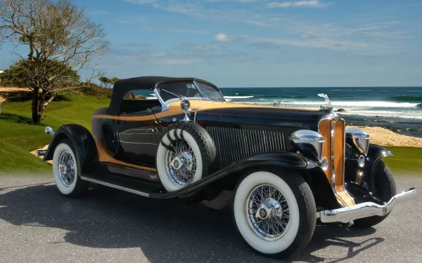 HD PC desktop wallpaper background: vintage Auburn convertible vehicle with whitewall tires parked on a coastal road under a blue sky