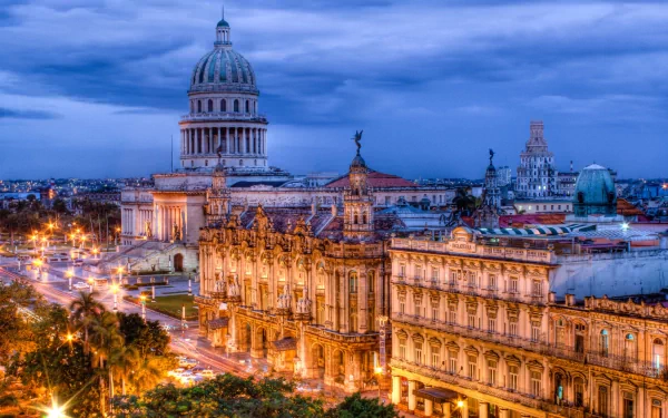 HD PC desktop wallpaper featuring a beautifully illuminated man-made townscape at dusk with historic architecture and a prominent domed building under a blue sky.