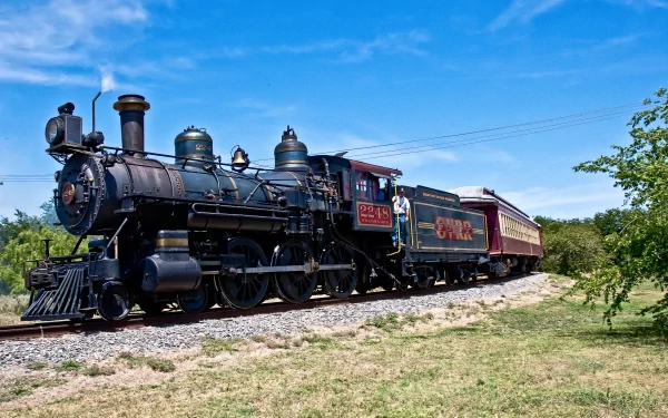 Black steam locomotive pulling a maroon passenger car on sunlit tracks under a vivid blue sky — 4K Ultra HD PC desktop wallpaper background featuring a vehicle, train in a rural setting