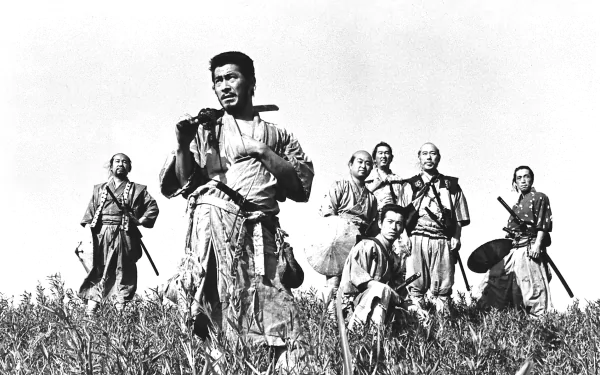 Black-and-white still from the movie Seven Samurai: seven samurai posed in a field with their leader in the foreground — HD PC desktop wallpaper and background.