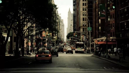 HD desktop wallpaper featuring a bustling New York street with vehicles and pedestrians, capturing the city's vibrant essence.