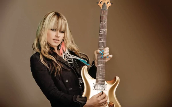 HD desktop wallpaper featuring musician Orianthi holding a gold electric guitar against a plain brown background.