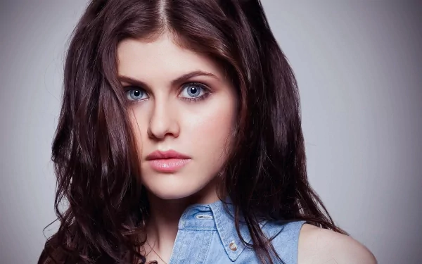HD desktop wallpaper featuring celebrity Alexandra Daddario with striking blue eyes and dark wavy hair, wearing a blue shirt.