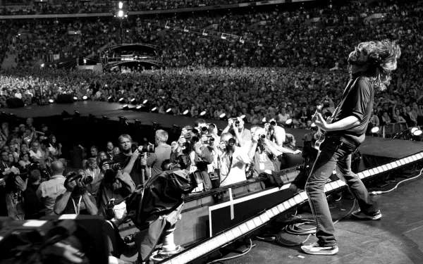 A dynamic black-and-white image of the Foo Fighters performing on stage, capturing the energy of a large crowd and the excitement of live music from an HD perspective.
