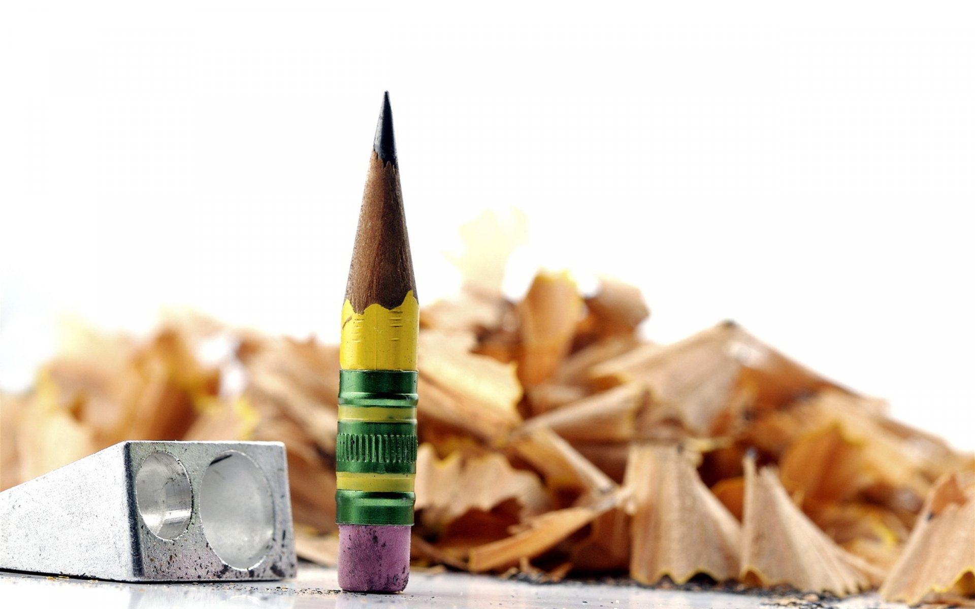 HD desktop wallpaper featuring a close-up photograph of a sharpened pencil, sharpener, and pencil shavings on a white background.