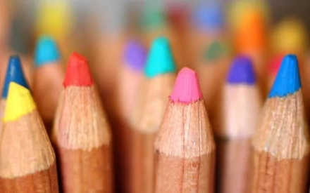 Close-up HD image of the tips of various colored pencils, creating a vibrant and artistic background.