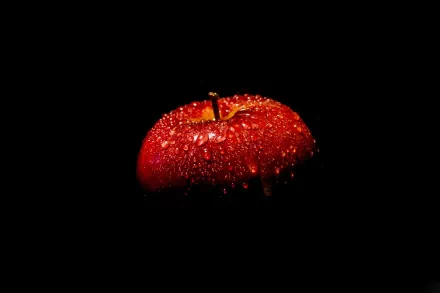 A close-up of a freshly washed red apple covered in droplets, set against a dark background, creating a striking and vibrant HD desktop wallpaper.