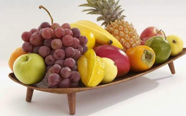 A vibrant assortment of fruits, including grapes, apples, bananas, and pineapple, elegantly arranged on a wooden platter, creating a colorful and inviting HD desktop wallpaper.