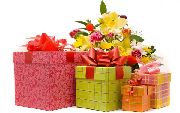 A vibrant collection of gift boxes in various colors, adorned with bows, sits alongside a bouquet of colorful flowers, creating a cheerful desktop wallpaper and background.