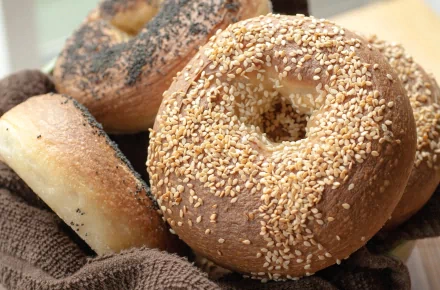 Close-up of sesame and poppy seed bagels arranged on a cloth, captured in high definition as a vibrant PC desktop wallpaper background.