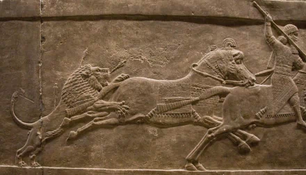 Artistic HD PC desktop wallpaper and background: Assyrian bas‑relief of a dramatic lion hunt, carved stone scene of lions leaping onto horses and chariots.