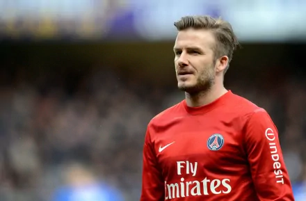 David Beckham stands on the field in a red PSG jersey, showcasing his iconic presence in sports. This HD image serves as an impressive desktop wallpaper.