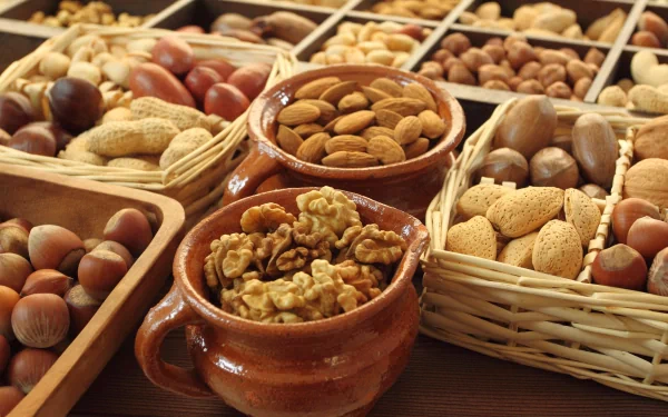 A vibrant display of various nuts in baskets and bowls, showcasing a rich assortment that celebrates the diversity of food. This 4K Ultra HD image serves as a stunning desktop wallpaper.