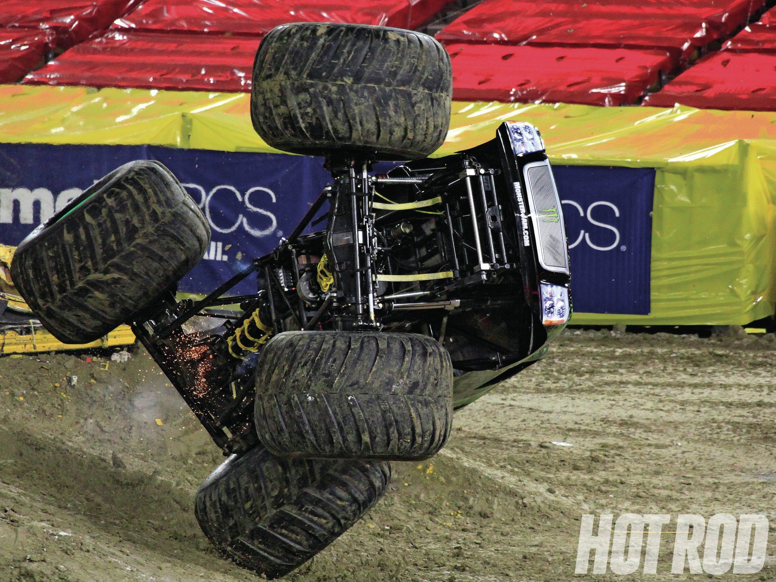 An exhilarating monster truck performs a spectacular stunt, showcasing its massive tires and powerful build in a dynamic scene. HD desktop wallpaper capturing the thrill of motorsport.