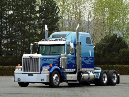 A striking Western Star truck in vivid blue with chrome detailing, set against a backdrop of trees, makes an impressive HD desktop wallpaper and background.