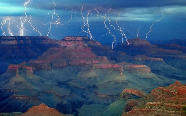 A stunning HD wallpaper of the Grand Canyon, showcasing dramatic lightning illuminating the rugged landscape against a moody sky. Nature's raw beauty captured in a moment of awe.