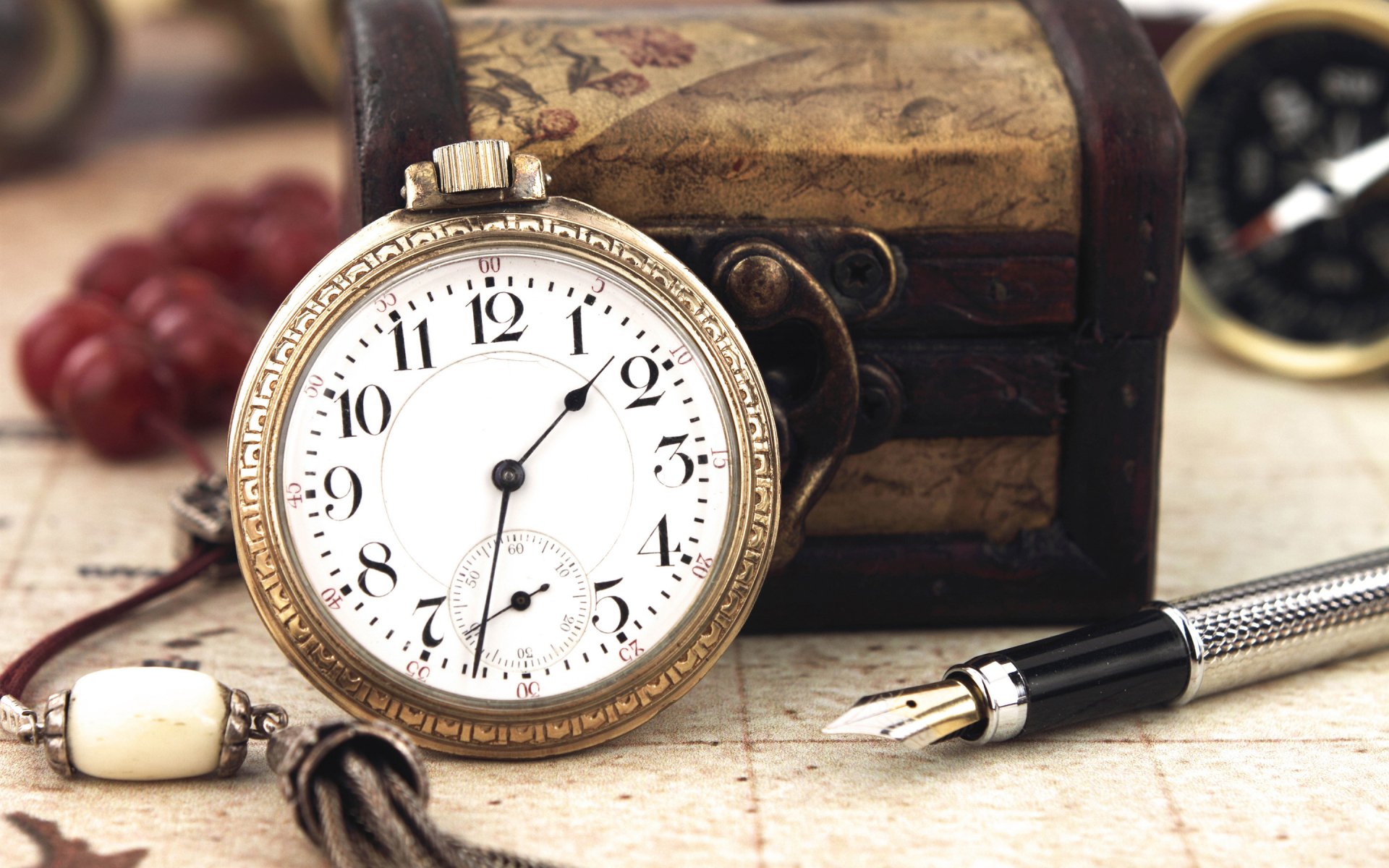 HD still life photography of a vintage pocket watch, an ornate wooden chest, and a fountain pen, designed as a PC desktop wallpaper and background.