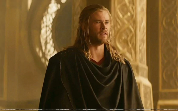 Chris Hemsworth as Thor in a detailed HD PC desktop wallpaper from the movie Thor: The Dark World, featuring a regal and intense pose in a golden-hued setting.