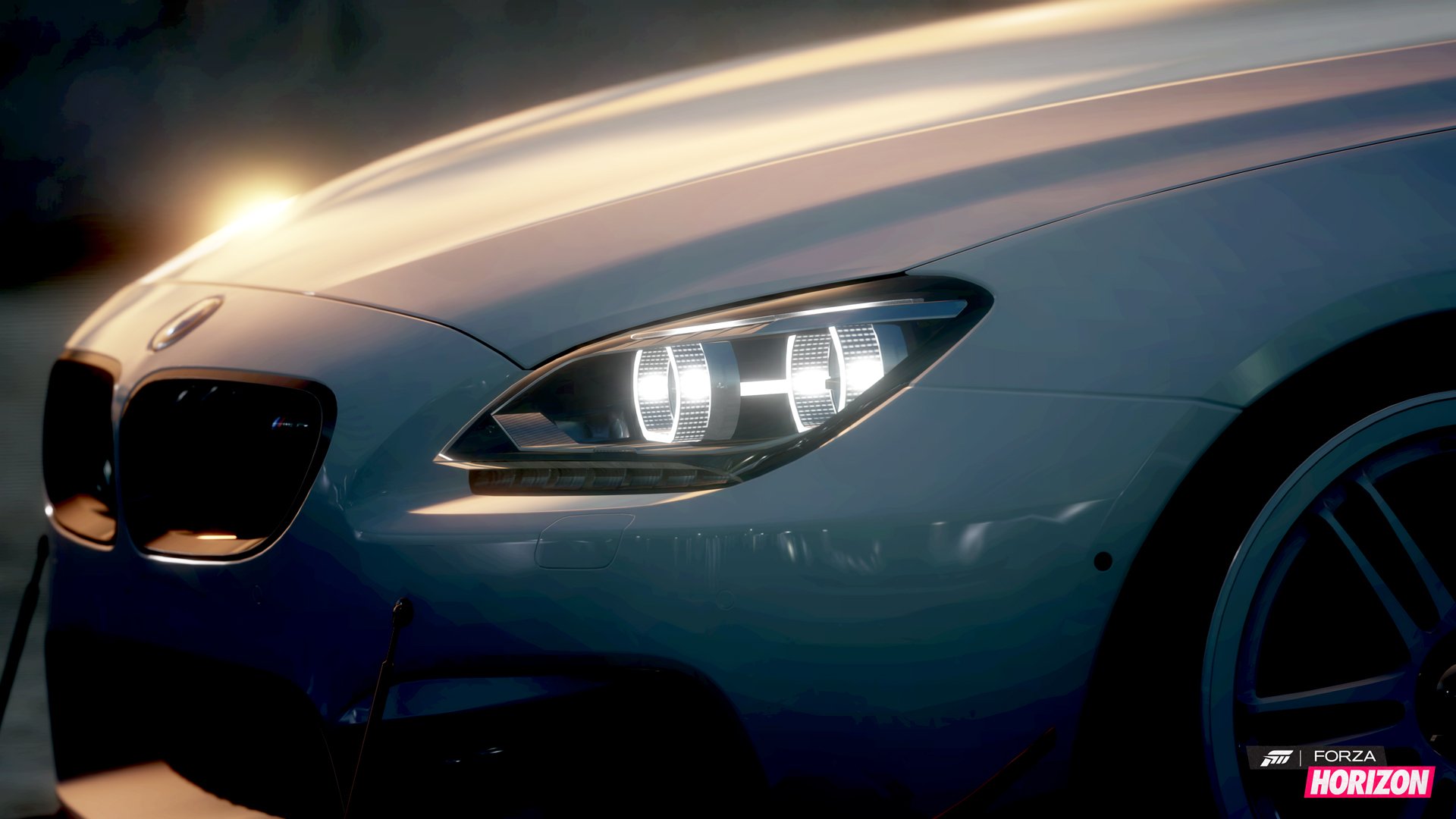 Close-up HD PC desktop wallpaper of a sleek BMW M6 headlight and front grille glowing in low light.