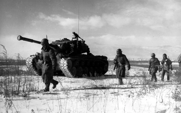 Black-and-white Korean War scene: soldiers walking past a tank across a snowy field — military 2K Quad HD PC desktop wallpaper and background.