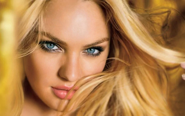 A close-up image of a woman with long blonde hair and striking blue eyes, creating an engaging backdrop for an HD PC desktop wallpaper.