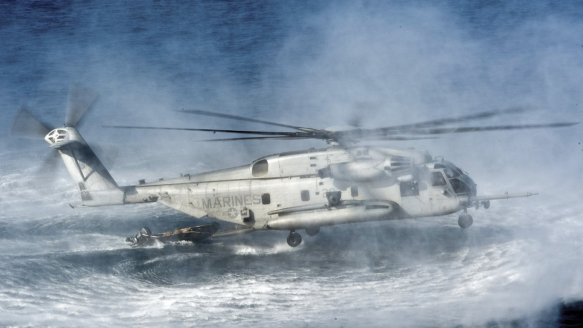 Military Sikorsky CH-53E Super Stallion helicopter flies low over rough sea waves in this HD PC desktop wallpaper and background.