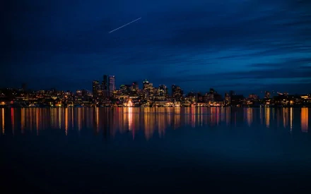 A stunning HD desktop wallpaper showcasing the Seattle skyline at dusk, reflecting vibrant city lights on calm waters, creating a serene urban landscape.