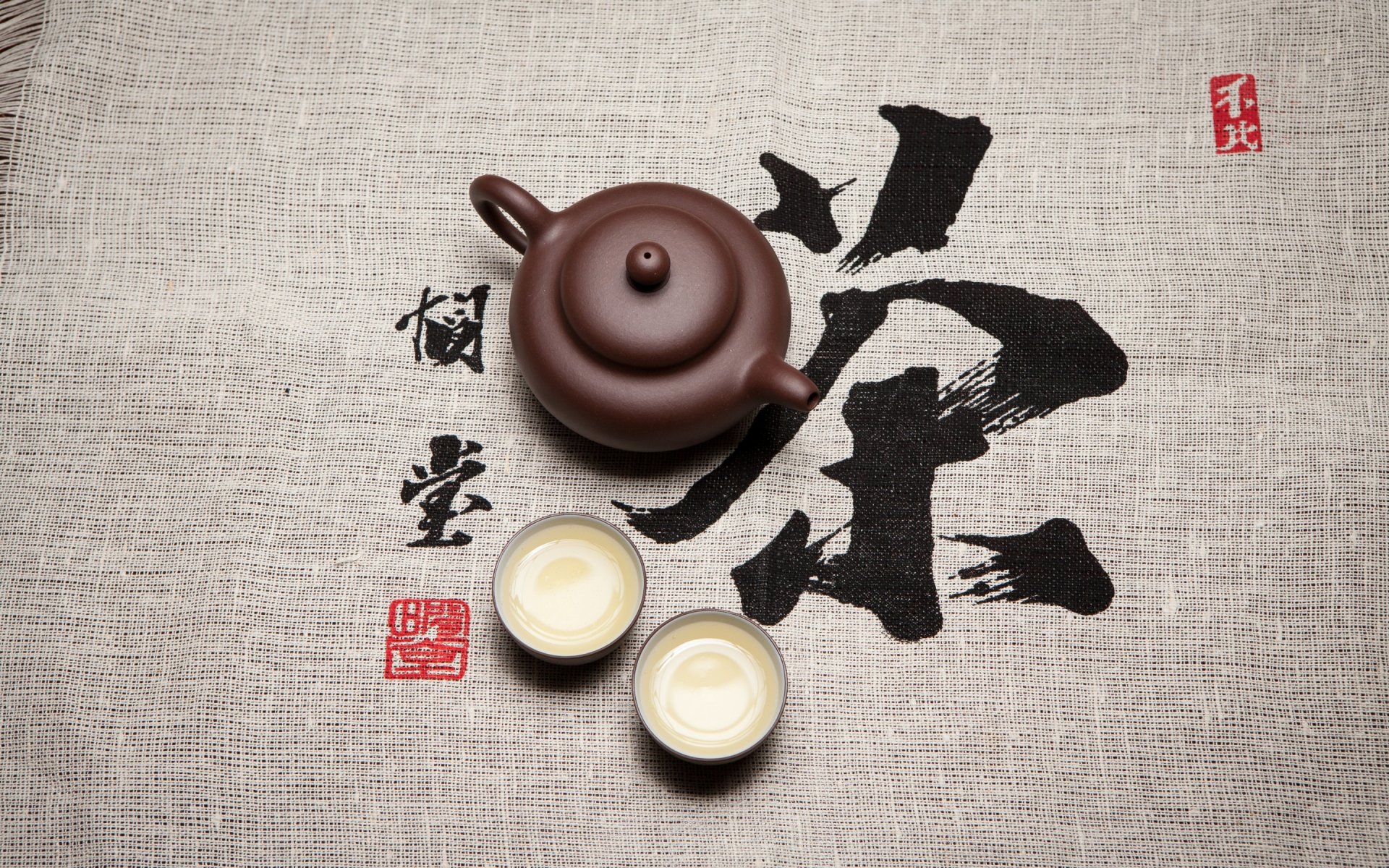 A serene tea setting with a teapot and two cups is displayed over a textured background featuring elegant Chinese characters, creating a soothing food and tea atmosphere.
