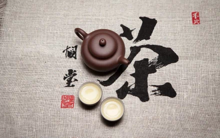 A serene tea setting with a teapot and two cups is displayed over a textured background featuring elegant Chinese characters, creating a soothing food and tea atmosphere.