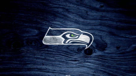 HD desktop wallpaper featuring the Seattle Seahawks logo prominently displayed on a textured, dark blue wooden background.