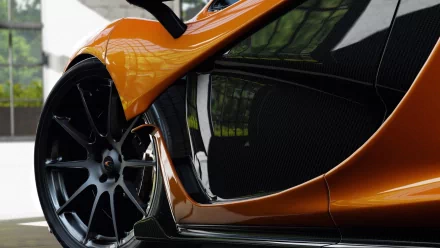 HD PC desktop wallpaper and background: close-up of an orange McLaren vehicle, highlighting the wheel, carbon-fiber side panel and glossy reflections.