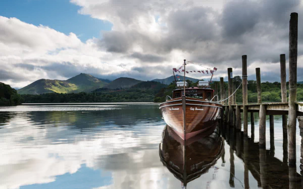 A serene scene featuring a boat docked by a wooden pier, reflecting in calm waters with mountains and a cloudy sky in the background, suitable as an HD PC desktop wallpaper.