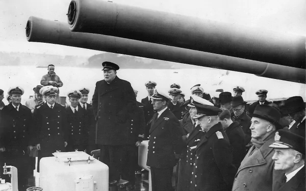 Black and white World War II military scene with naval officers gathered under large battleship guns, captured in a detailed 4K Ultra HD desktop wallpaper.