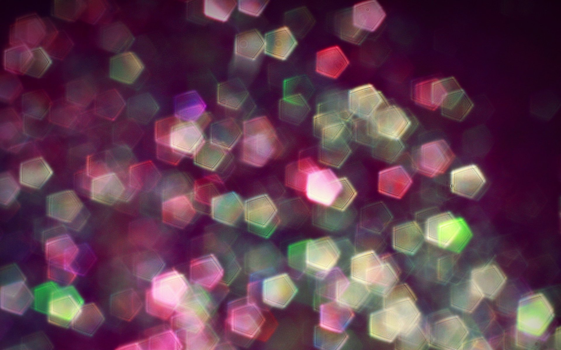 An abstract and artistic HD wallpaper features a blend of colorful hexagonal shapes softly blurred against a dark background, creating a dynamic and visually engaging desktop backdrop.