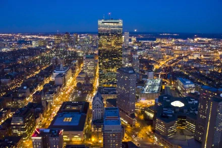 A stunning HD wallpaper showcasing Boston's skyline at dusk, highlighting the illuminated buildings and bustling streets in a vibrant cityscape.